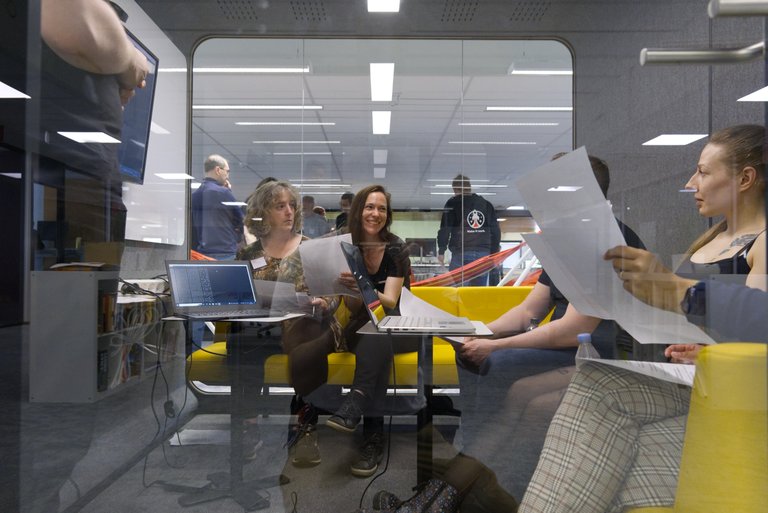 Tuxera team working together behind glass