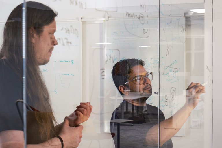 Tuxera engineers working on a glass whiteboard